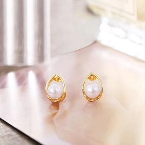Detailed close-up of French vintage gold pearl earrings with teardrop metal frame