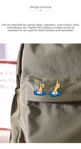 Close-up of creative thumbs-up gesture pins on a gray canvas bag pocket
