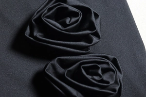 Close-up of 3D fabric rose details on a black sexy backless casual mini dress