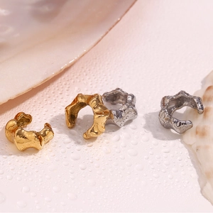 Lava texture bamboo ear cuffs in gold and silver finish shown on shell and water background