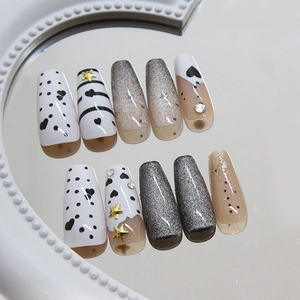 Cat eye press-on nails with silver glitter, black heart patterns and golden 3D stars