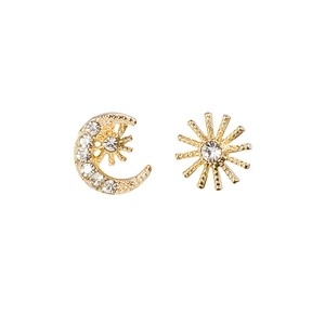 Close-up of asymmetric gold sun and moon earrings with sparkling zircon inlay