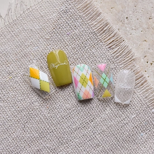 Detail of colorful argyle pattern and script print on glossy press-on nail set