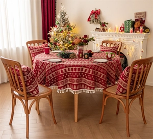 Close-up of red Christmas reindeer tablecloth with white fringe and matching cushions