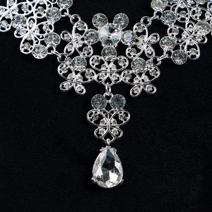 Close-up of bridal necklace with silver butterfly pattern and teardrop crystal pendant