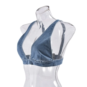Dettaglio del top in denim che mostra la trama lavata e le cuciture da un angolo di 45°