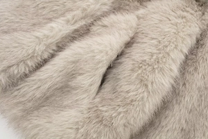 Macro shot of fluffy light grey faux fur fabric texture showing soft plush material detail