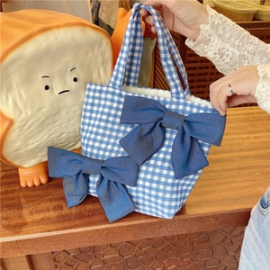 Detail view of blue gingham lunch bag featuring large denim-style double bows and soft handles