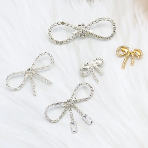 Elegant vintage bow brooches set with rhinestones and pearls on soft white fur background
