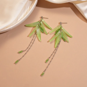 Detail of green acrylic bamboo leaf tassel earrings with silver needles and metal chains