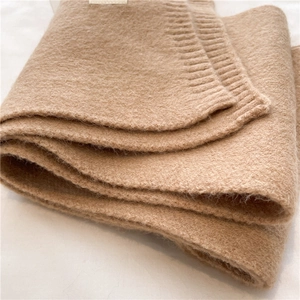 Close-up of khaki wool blend knitted scarf showing soft ribbed texture and thick yarn