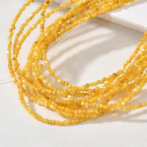Macro shot of 2-2.5mm natural yellow shell round beads for DIY handmade jewelry crafts