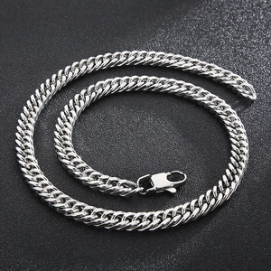 Detail of silver Cuban link necklace with lobster clasp on a black textured background