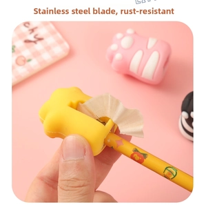 Close-up of yellow cat paw pencil sharpener showing stainless steel blade in use