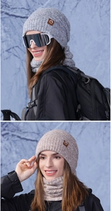 Close-up of thick knitted winter hat and neck warmer set with leather logo patch