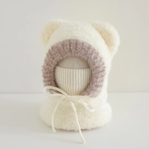 Close-up of warm cream teddy fleece kids hat with brown faux fur trim and bear ears