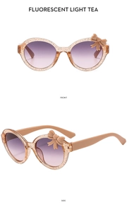 Front and side views of bow-knot kids sunglasses in fluorescent light tea with gold glitter