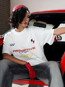 Λεπτομέρεια από λευκό oversized t-shirt με αγωνιστικά prints σε κόκκινο σπορ αυτοκίνητο
