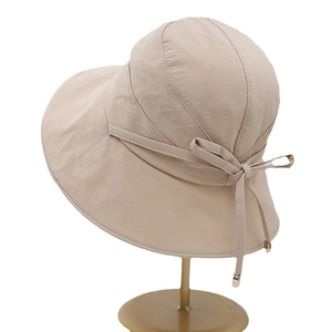 Women's UV protection wide brim sun hat in beige with decorative bow tie and metal trim