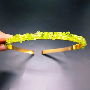 Detailed close-up of green crystal stone crown with golden metal wire handmade headband