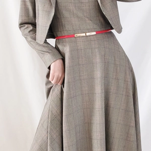 Slim red leather belt with gold buckle on a plaid suit set for women's waist accent