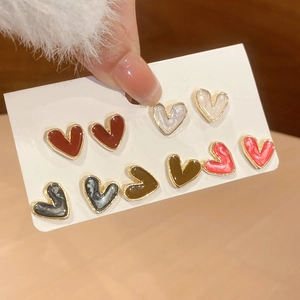 Detail view of heart-shaped earring set in five colors on display card with gold metal trim