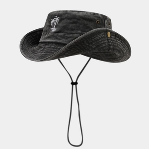 Detailed embroidery of a white coconut tree on a vintage black washed cotton hiking hat