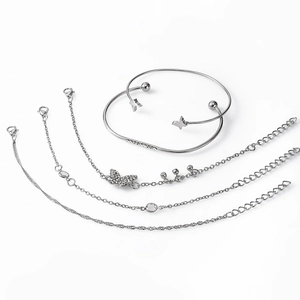 Macro detail of 5-piece silver bracelet set with butterfly charms and crystal accents
