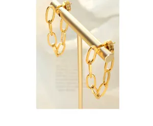 Close-up of bohemian gold-plated chain earrings on a premium display stand