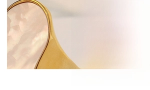 Macro shot of the irregular white seashell inlay and 18k gold-plated steel ring band