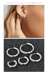 Macro detail of polished stainless steel hoop earrings with sparkling cubic zirconia inlay