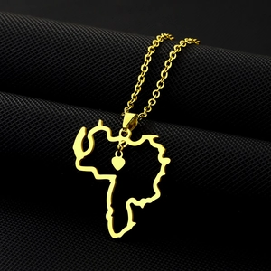 Detailed close-up of golden Venezuela map pendant with small heart on a dark background