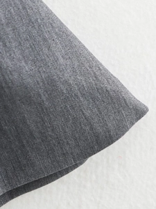 Détail en gros plan de la texture du tissu gris et du motif tissé pour haut cintré femme