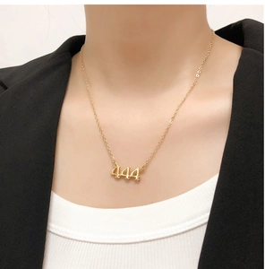 Close-up of gold number 444 pendant necklace in Old English font on a model