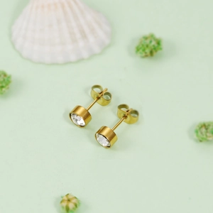 Vue de près des boucles d'oreilles dorées en acier inoxydable avec cristaux ronds brillants