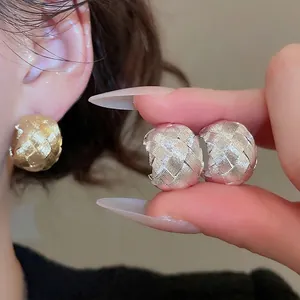Minimalist C-shaped stud earrings with intricate metallic woven cross texture design