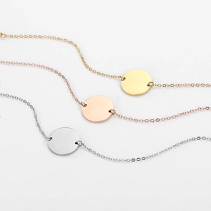Macro shot of minimalist round charm bracelets in gold, rose gold and silver finishes