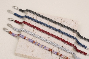 Detail of 18K gold-plated bracelets with colorful rectangular gemstone inlays