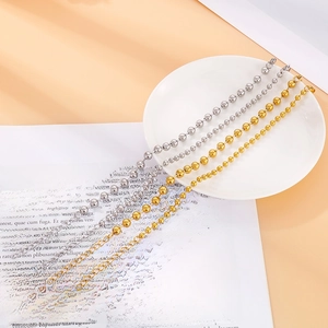 Pulseras de cuentas de acero de titanio doradas y plateadas para mujer en un plato blanco