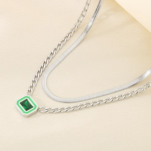 Detail of silver double-layer necklace with emerald green rectangular pendant and snake chain