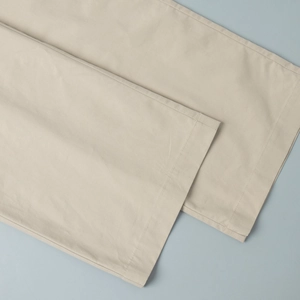 Detailed close-up of beige casual trouser hem featuring high-quality single-needle stitching