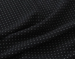 Detail shot of black fabric with white polka dots showing smooth drape and texture