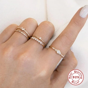 Macro shot of five stacked S925 sterling silver gold-plated rings with white zircons