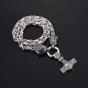 Macro detail of Viking Mjolnir hammer pendant with wolf heads on a stainless steel chain