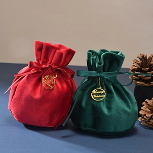 Detail of red and green velvet Christmas gift bags with silk ribbons and gold tags