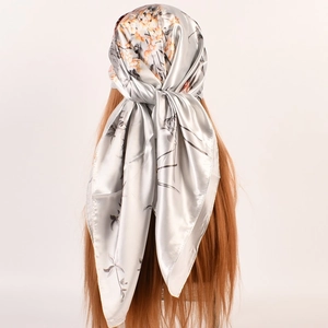 Eleganter silberner Satin-Viereckschal mit Pfingstrosendruck auf braunem Haarmodell