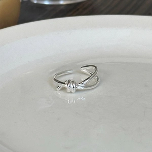Minimalist S925 sterling silver knotted open ring shown on a white ceramic plate