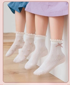 Close-up of girls mesh socks with floral prints, pink bows and scalloped lace cuffs