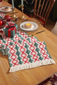 Detailed texture of cotton Christmas table runner with red and green tassels