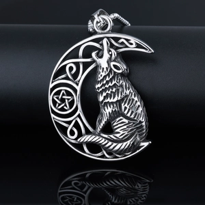 Macro shot of punk style stainless steel wolf and crescent moon pendant with celtic patterns